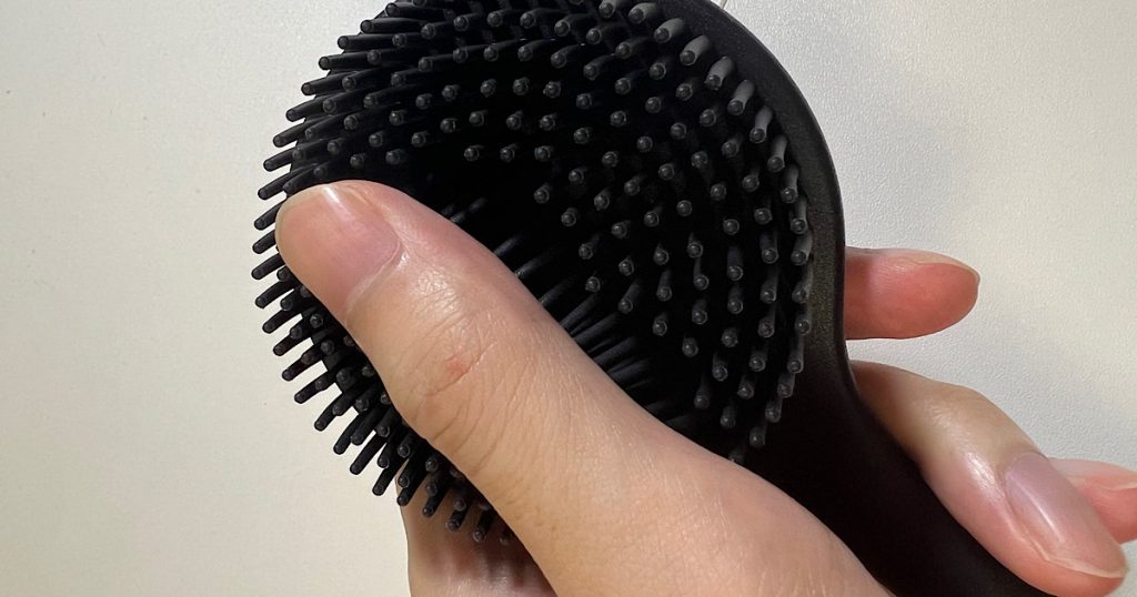 背中ブラシのブラシ面を指で触り心地を確かめている