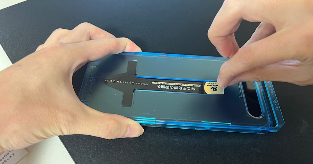 スマホにフィルム取付ガイドを取付けている写真
