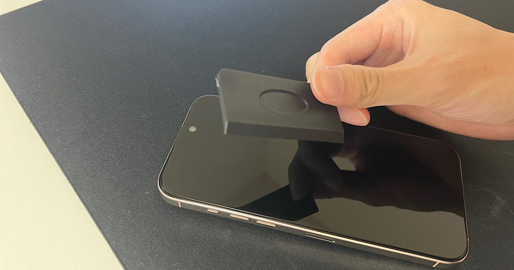 ヘラを使って画面の気泡を取り出そうとしている写真