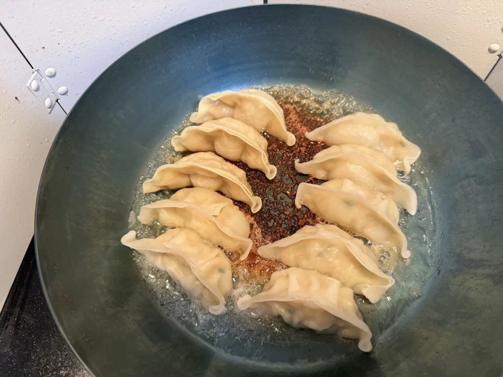 冷凍餃子を鉄フライパンで焼いている様子
