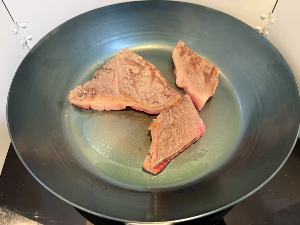 鉄フライパンでステーキの片面を焼いた状態