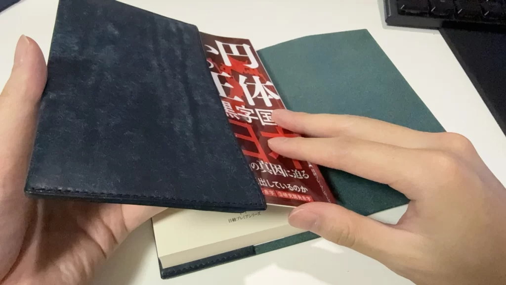 本に差し込んだ状態で残りのカバーパーツを合わせようとしている様子