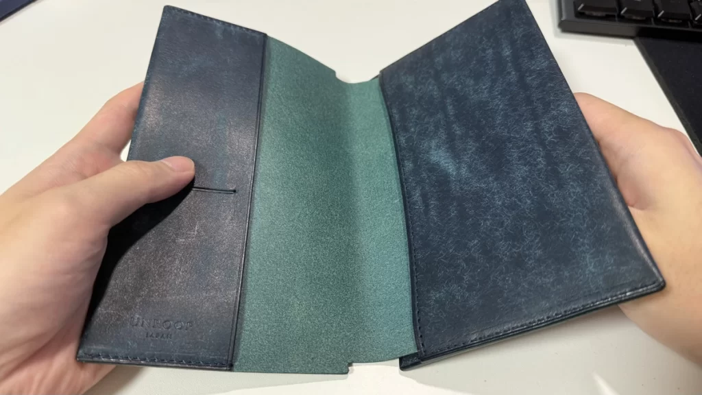手に持ったUNROOF本革ブックカバーを開き内側を写した写真