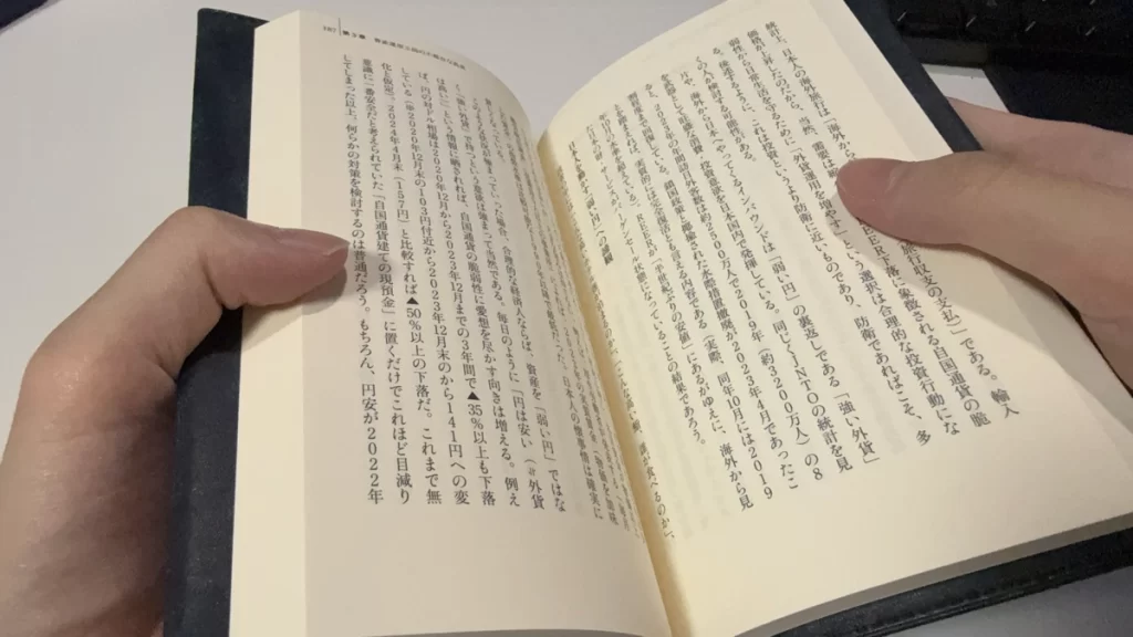 両手でページをめくりながら読む場面。カバーが硬すぎずページが大きく開き、読みやすい状態。
